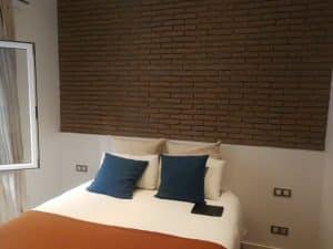Un dormitorio decorado con paneles de ladrillo rustico