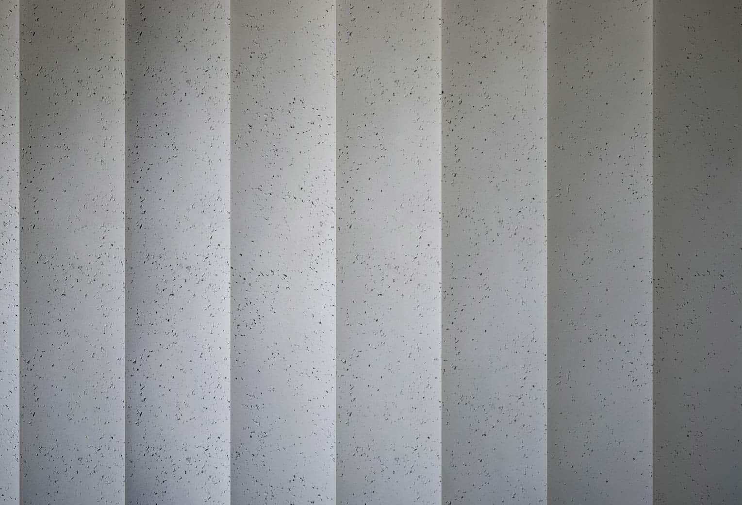 Panel decorativo NEOS textura imitación cemento en una pared de una casa, hotel, oficinas o exposición